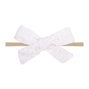 Détail d'un bandeau en dentelle blanche avec nœud brodé pour bébés et enfants