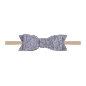Détail d'un nœud en feutre gris sur un bandeau souple montrant la texture du tissu