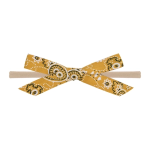 Detail of baby headband featuring ginger paisley floral bow and soft elastic nylon strap