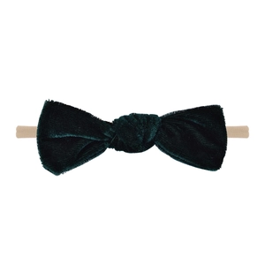 Detailed close-up of handmade dark green velvet bow headband with soft nylon elastic band