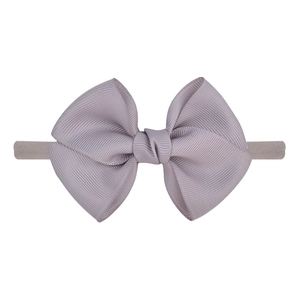 Détail du nœud en gros-grain lilas sur un bandeau extensible pour bébé en nylon