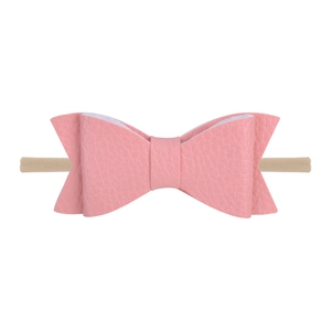 Detailed macro shot of pink faux leather bow headband with soft seamless nylon band