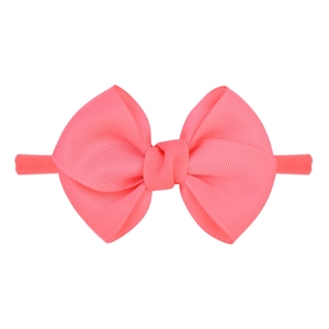 Détail du nœud en ruban gros-grain corail sur bandeau élastique souple pour bébé