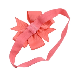 Soft coral pink baby headband with large ribbed grosgrain ribbon bow on elastic band