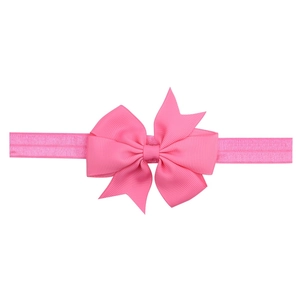 Detail of pink grosgrain ribbon bow on a soft elastic headband for infants and babies