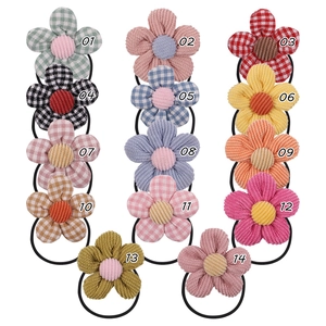 Detailed grid of 14 colorful floral hair ties in corduroy and plaid fabrics