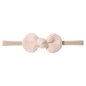 Close-up of pink waffle texture knit bow and high elastic nylon headband for babies