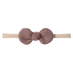 Close-up of baby waffle knit bow headband with soft texture and elastic nylon band
