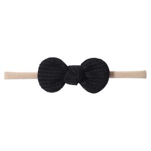 Close-up of black waffle fabric knot bow with beige high-stretch nylon baby headband