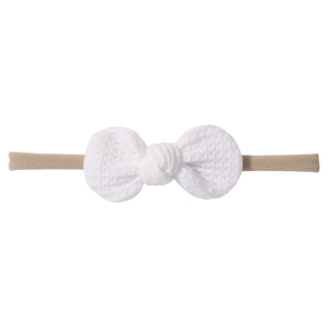 Infant waffle knit headband with white bow and beige elastic band on white background