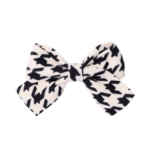 Detail of classic black and white houndstooth fabric bow hair clip with neat edge stitching