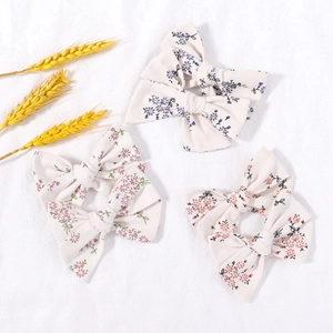 Detail of floral fabric bow hair clips set with pastoral patterns on white background