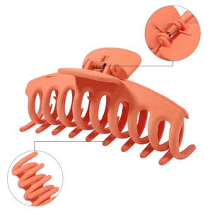 Detail view of matte orange hair claw clip showing metal spring and sturdy multi-teeth design