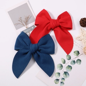 Vintage plush bow hair clips in red and deep blue styles with thick texture and ribbon design