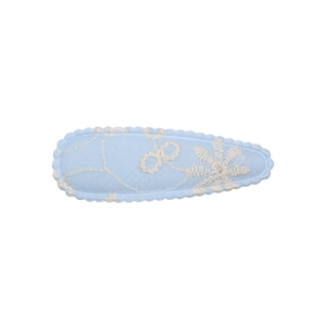 Detail of light blue fabric BB hair clip featuring white floral embroidery and scalloped edges