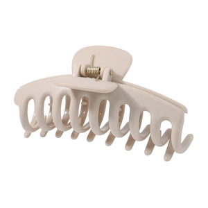 Detail of matte beige large hair claw clip with golden spring on white background