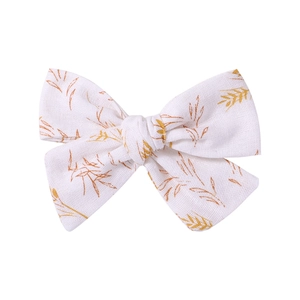 Floral bow hair clips with golden wheat patterns on white fabric for girls' ponytails