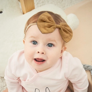 Close-up of baby girl wearing an apricot nylon headband with a caramel waffle bow accessory