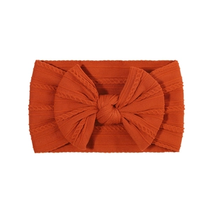 Bandeau orange brûlé pour bébé fille avec un grand nœud en maille jacquard