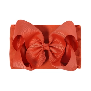 Détail du bandeau en nylon orange pour bébé avec un grand nœud en ruban gros-grain