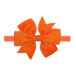 Dettaglio della fascia per neonati arancione elastica con fiocco in nastro grosgrain