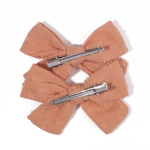 Close-up of pink polka dot fabric bow hair clips with silver metal crocodile clips