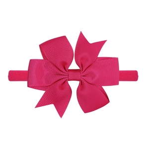 Dettaglio del fiocco in gros-grain rosa su fascia elastica in nylon per neonati