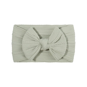 Sage green knitted nylon baby headband with large bow detail on white background