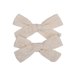 Close-up of cream cotton hair clips with delicate floral embroidery for girls