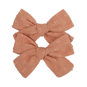 Set of two soft pink fabric hair clips with swiss dot pattern and double bow design