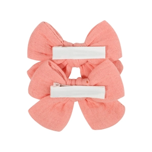 Pair of soft pink fabric bow hair clips for babies with cotton linen texture