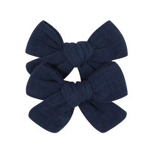 Close-up of deep blue handmade fabric hair bows with detailed woven texture for girls
