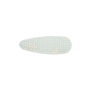 Détail d'une pince à cheveux en tissu à carreaux verts avec broderie florale