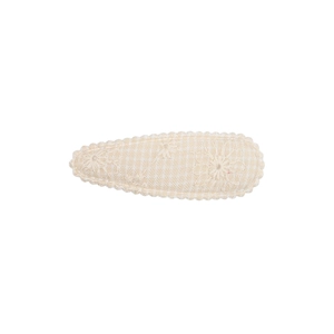 Gros plan sur une barrette beige avec broderie florale et bordure en dentelle fine