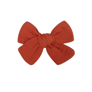 Handmade rust red fabric bow hair clip for babies with natural cotton linen texture