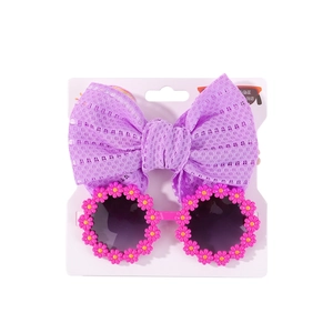 Detail von lila Netz-Stirnband mit Schleife und rosa Gänseblümchen-Sonnenbrille für Kinder
