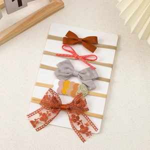 Detail view of five different handmade baby headbands with bows on a display card