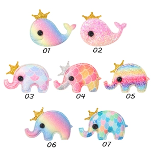 Close-up of sequin glitter whale and elephant hair clips with crown detail