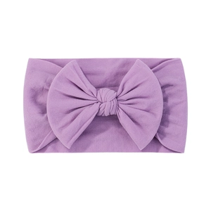 Dettaglio della fascia elastica lilla per neonati con grande fiocco fatto a mano in nylon
