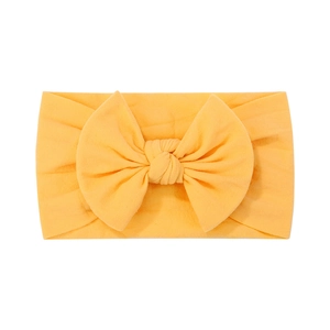 Dettaglio della fascia elastica in nylon arancione con un grande fiocco decorativo