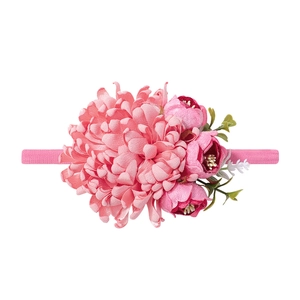 Dettaglio della fascia per neonata con fiori rosa finti e morbido elastico in nylon