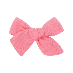 Close-up of pink handmade bow hair clip showing textured cotton linen fabric detail