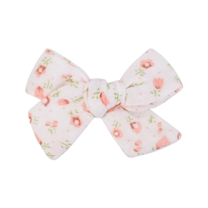 Detail of floral linen bow hair clip for kids featuring pink blossoms on cream fabric