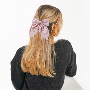 Sweet pink purple oversized bow hair clip shown on a model in a minimalist style