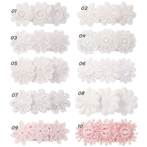 Detailed macro view of white and pink lace flower embroidery clips in various styles