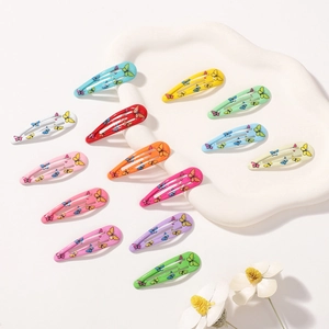 Gros plan de douze barrettes papillon colorées avec une finition laquée macaron