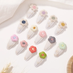 Close-up of 12-piece mini flower hair clips with hand-embroidered fabric floral details