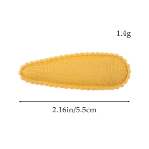 Détail d'une pince à cheveux jaune en tricot avec bords festonnés mesurant 5,5 cm