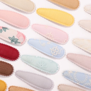 Détail de barrettes BB pour filles avec broderie et bordures en dentelle ondulée
