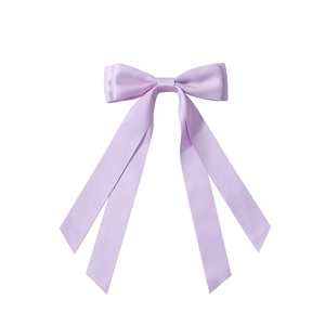 Détail de la pince à cheveux en satin lavande avec double nœud et longs rubans élégants